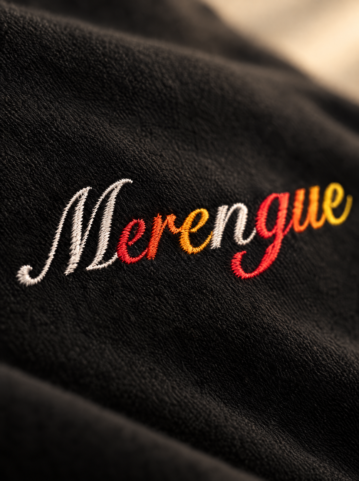 Black — Fabric & print close-up, hand-lettered Merengue script