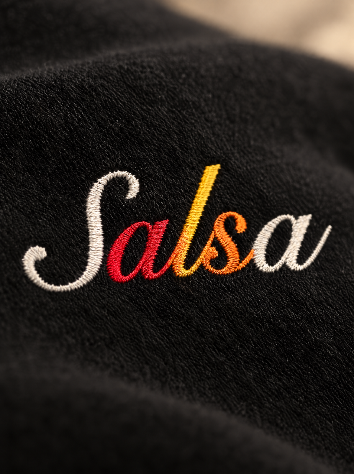 Black — Fabric & print close-up, hand-lettered Salsa script